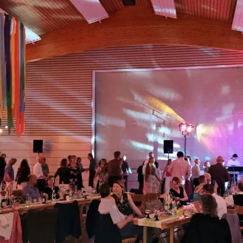 Festliche Abendveranstaltung im TSG Sonnenberg mit Tanz, Musik und Gesellschaft in modernem Veranstaltungsraum.